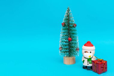 Yüz maskeli kardan adam hediyeler ve kopyalanmış noel ağacı. Noel ve yeni yıl kutlaması..