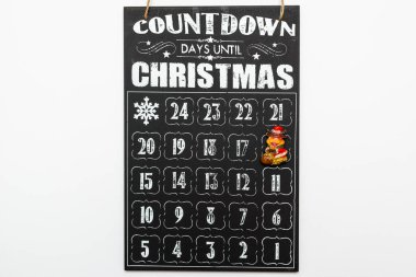 Toy bull on black wooden advent calendar showing Christmas countdown top view flat lay white background. clipart