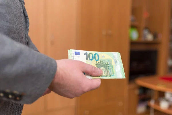 Business man hand giving money like a bribe or tips. Holding euro banknotes.