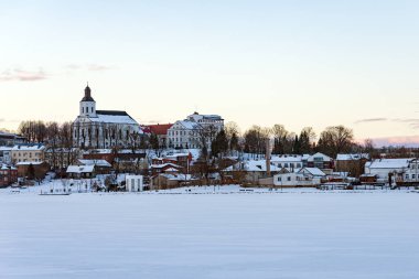 Litvanya 'daki Telsiai kasabası ve gölü. Donmuş Laklar kıyısındaki renkli evlerin güzel manzarası. Güzel bir kış akşamı..