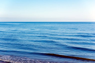 Derin mavi ve dalgalı bir deniz manzarası. Bir sürü deniz püskürtüsü. Mavi arka plan..