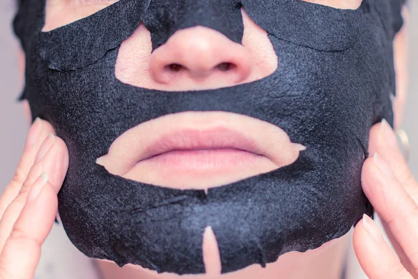 Young Woman Apply Black Cosmetic Fabric Facial Mask Home Face — Stock Photo, Image