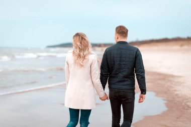 Sevgili çift kumsalda dinleniyor. Aşk konsepti tatili. Geriye bakış. Pring, sonbahar tatili..