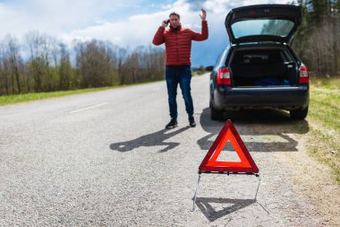 Araba bozulduktan sonra tamirciyi arayan adam. Yolda cep telefonuyla konuşan adam. arızalı araba.