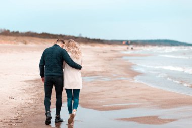Sevgili çift kumsalda dinleniyor. Aşk konsepti tatili. Geriye bakış. Pring, sonbahar tatili..