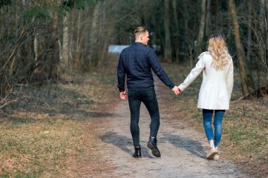 İlkbaharda ormanda yürüyüşe çıkan güzel bir çift, sonbaharda açık havada güneşli bir gün..