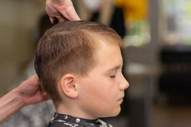 Berber dükkanında saç tıraşı olan sevimli bir çocuk. Yakından..