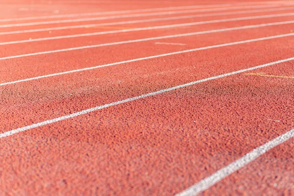 Part Red plastic track in the outdoor track and field stadium.Closeup.
