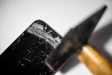 Bozuk ekranlı çekiç ve akıllı telefon. Elektronik tamir servisi. Akıllı telefonu kır. Kapalı alanda çekim yap..