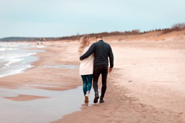 Sevgili çift kumsalda dinleniyor. Aşk konsepti tatili. Geriye bakış. Pring, sonbahar tatili..