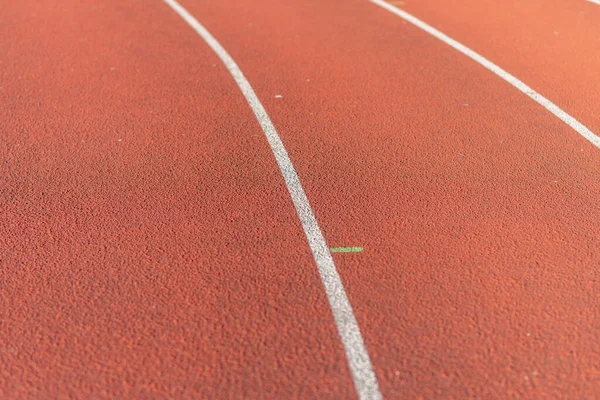 Part Red plastic track in the outdoor track and field stadium.Closeup.