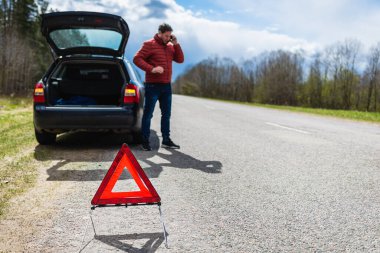 Araba bozulduktan sonra tamirciyi arayan adam. Yolda cep telefonuyla konuşan adam. arızalı araba.