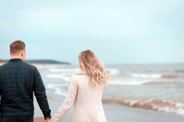 Sevgili çift kumsalda dinleniyor. Aşk konsepti tatili. Geriye bakış. Pring, sonbahar tatili..