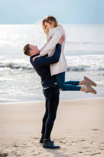 Genç çift sahilde eğleniyor ve eğleniyor. Bahar, sonbahar, sonbahar tatili..