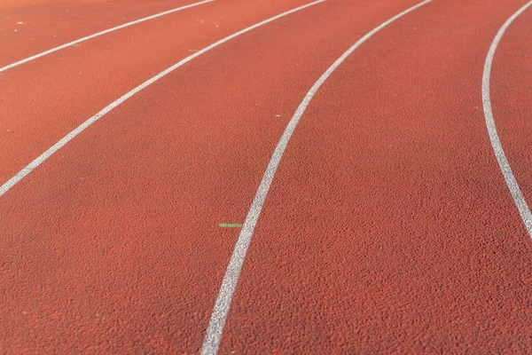 Part Red plastic track in the outdoor track and field stadium.Closeup.