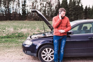Araba bozulduktan sonra tamirciyi arayan adam. Yolda cep telefonuyla konuşan adam. arızalı araba.