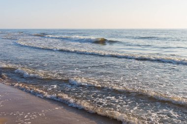 Derin mavi ve dalgalı deniz manzarası, bol bol deniz spreyi. Mavi arka plan. Odaklanma, bulanık görüntü..