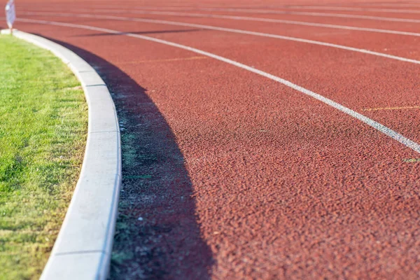 Part Red plastic track in the outdoor track and field stadium.Closeup.