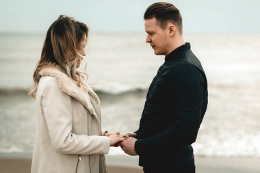 Genç çift kumların üzerinde eğleniyor ve eğleniyorlar. Yaz, bahar, sonbahar tatili..