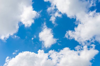 Mavi gökyüzünde beyaz ve gri bulutlar. Sıcak bahar ya da yaz mevsiminde güzel bir gün. Kopya alanı..