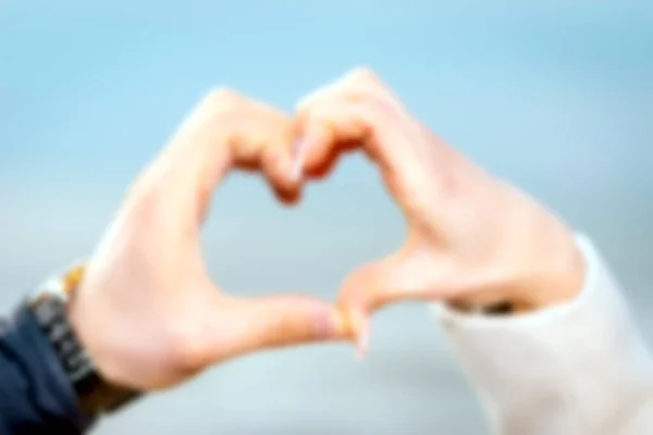 Borrosa Manos Masculinas Femeninas Forma Corazón Sobre Fondo Del Mar —  Fotos de Stock