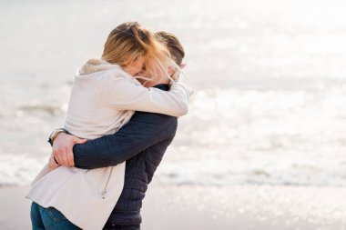 Genç çift sahilde eğleniyor ve eğleniyor. Bahar, sonbahar, sonbahar tatili..