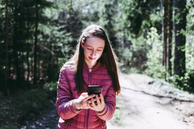 13. yaş gününden bir kız, ormandaki arkadaşına internetten telefon ediyor. Güneşli bir yaz ya da bahar günü..