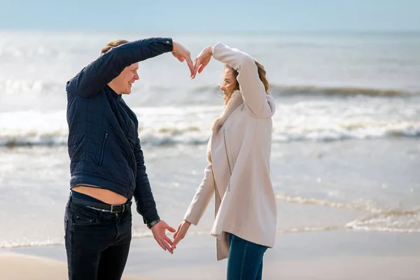 Jong Stel Maken Hart Vorm Met Armen Zee Strand Tegen — Stockfoto