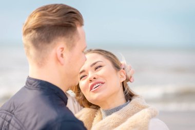 Genç çift sahilde eğleniyor ve eğleniyor. Bahar, sonbahar tatili. Kapanış..