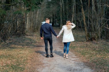 İlkbaharda ormanda yürüyüşe çıkan güzel bir çift, sonbaharda açık havada güneşli bir gün..