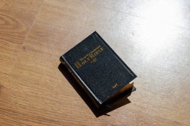 Hafif ahşap arka planda İncil. Kutsal İncil. Eski kutsal kitap kapandı. Siyah kutsal İncil masanın üstünde..