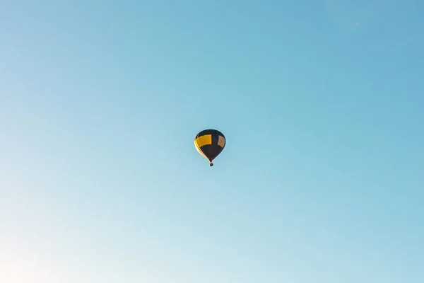 Balon Gorące Powietrze Leci Niebieskim Nieba Jeden Niebieski Żółty Balon — Zdjęcie stockowe