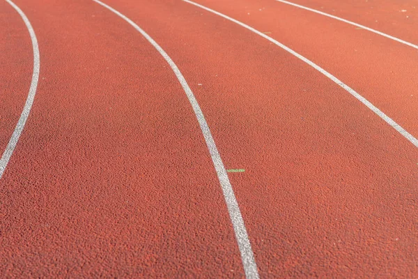 Part Red plastic track in the outdoor track and field stadium.Closeup.