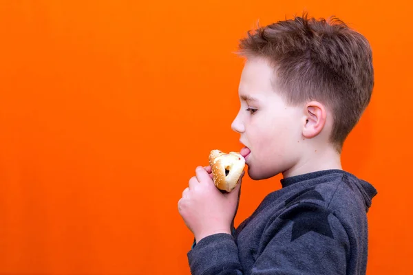 Handsome Yers Old Boy Holding Biting Hot Dog Indoors Orange — ストック写真