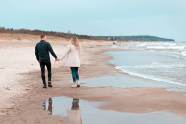 Sevgili çift kumsalda dinleniyor. Aşk konsepti tatili. Geriye bakış. Pring, sonbahar tatili..