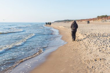 Baharda kumsalda sırt çantalı bir bayan gezgin. Palanga, Lthuania 28,04,2021
