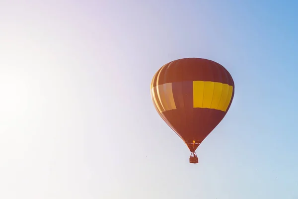 青い空に熱気球が飛んできます 青い澄んだ空に青い黄色い熱気球が一つ — ストック写真