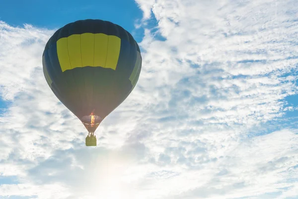 Hot Air Balloon and blue sky,sun, white cloud.Blue yellow hot air balloon in the air at summer evening.