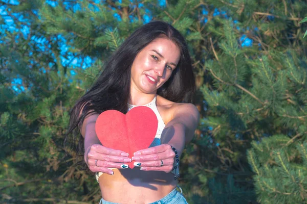 Güzel Esmer Kırmızı Kalp Kartpostalını Gösteren Rüya Gibi Gülümseyen Yaz — Stok fotoğraf