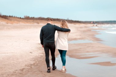 Sevgili çift kumsalda dinleniyor. Aşk konsepti tatili. Geriye bakış. Pring, sonbahar tatili..