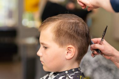 Berber dükkanında saç tıraşı olan sevimli bir çocuk. Yakından..