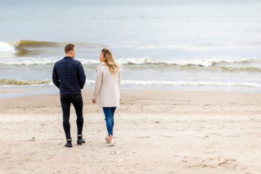 Sevgili çift kumsalda dinleniyor. Aşk konsepti tatili. Geriye bakış. Pring, sonbahar tatili..