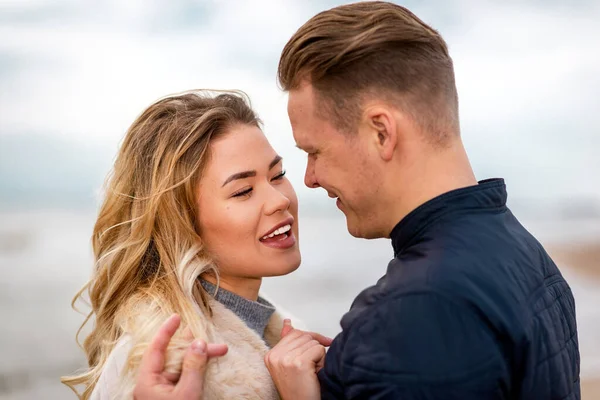 Genç çift sahilde eğleniyor ve eğleniyor. Bahar, sonbahar tatili. Kapanış..