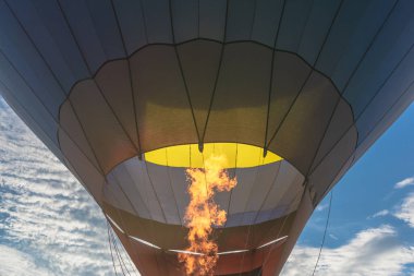 Sıcak hava balonunun içindeki gaz ocağının alevi yaz akşamında yanar..