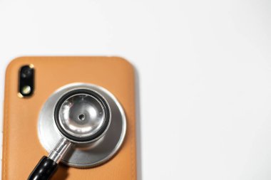 Akıllı telefonlu steteskop. beyaz, çözümü için soyut arkaplan ya da akıllı telefon için çözüm anahtarı. Beyaz arkaplanda cep telefonlu stetoskop.