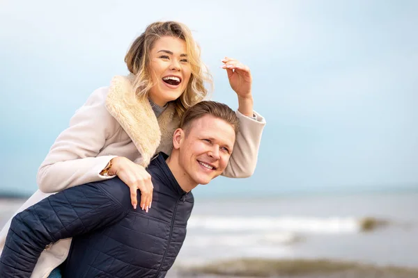 Homem Feliz Dar Boleia Para Mulher Rir Uma Praia Sorrindo — Fotografia de Stock