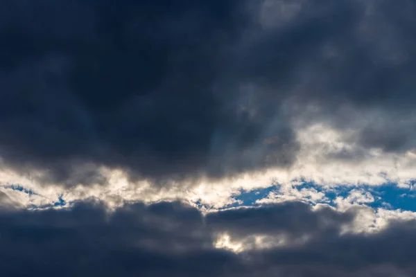 暗い雲の中で輝く光の光線 太陽が昇る美しい劇的な空 — ストック写真