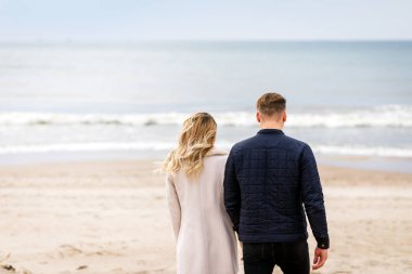 Sevgili çift kumsalda dinleniyor. Aşk konsepti tatili. Geriye bakış. Pring, sonbahar tatili..