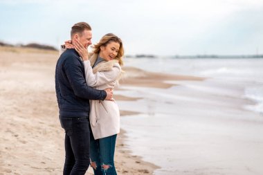 Young couple enjoying on a coast and enjoying each other.Summer,spring,autumn vacation.Copy space.