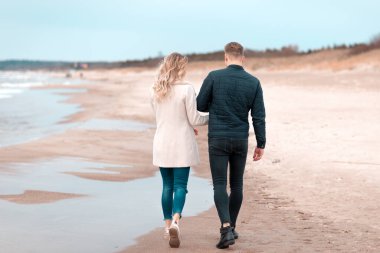 Sevgili çift kumsalda dinleniyor. Aşk konsepti tatili. Geriye bakış. Pring, sonbahar tatili..